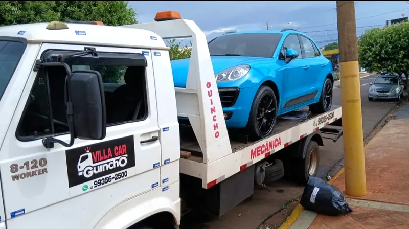 Guincho plataforma da Vila Car transportando um Porsche Macan azul em Ribeirão Preto